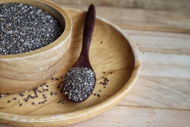 Kahverengi ahşap arka planda Chia tohumları