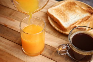 Kahvaltı portakal suyu yaz içeceği ve sade kahve tostu.