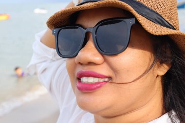 Asyalı kadın sahilde mutlu bir gülümseme