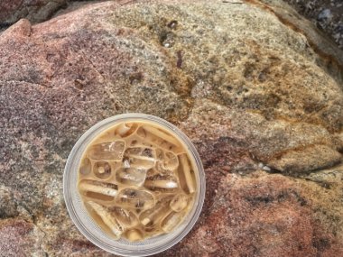 Kahverengi taşın üzerinde buzlu kahve. 