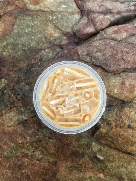 Kahverengi taşın üzerinde buzlu kahve. 