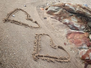 Kalpler kumsalda çizilmiş.