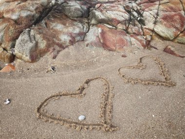 Kalpler kumsalda çizilmiş.