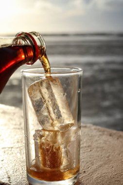 Buzlu bardağa kola dök.