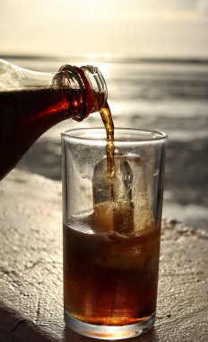 Buzlu bardağa kola dök.