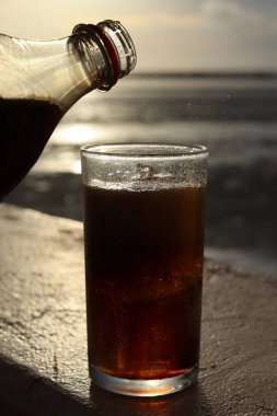 Buzlu bardağa kola dök.