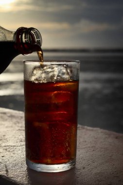 Buzlu bardağa kola dök.