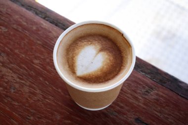 Süt köpüklü kahve, ahşap arka planda.