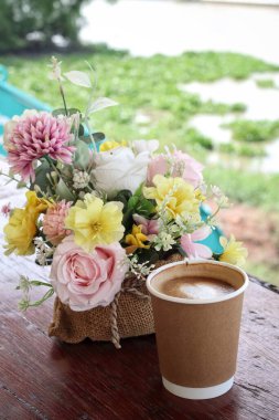 Süt köpüklü kahve ve çiçek.