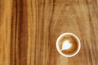 Süt köpüklü kahve, ahşap arka planda.