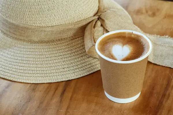 Süt köpüklü sütlü kahve ve şapka.