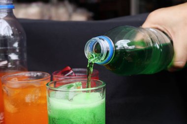 İçecekler ve buzlar kadehe dökülüyor.