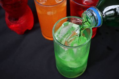 İçecekler ve buzlar kadehe dökülüyor.