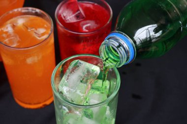 İçecekler ve buzlar kadehe dökülüyor.