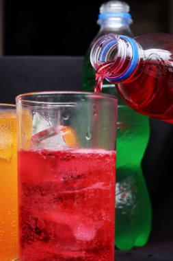 İçecekler ve buzlar kadehe dökülüyor.