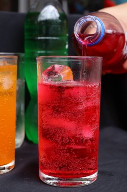 İçecekler ve buzlar kadehe dökülüyor.