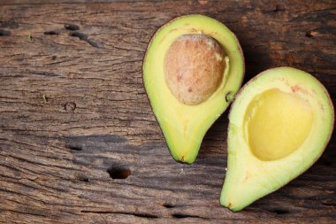 Ahşap arka plan üzerinde taze avokado yarım