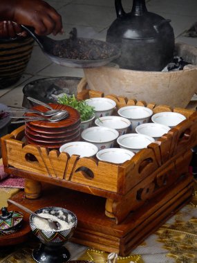Woman pouring coffee in cups as part of a traditional coffee ceremony performed in Ethiopia, Africa.