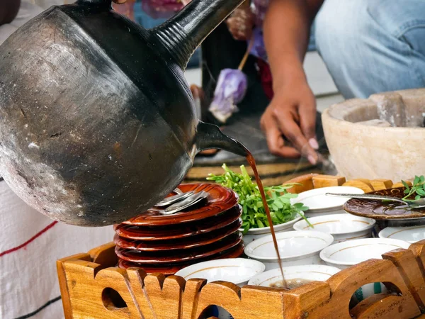 Woman pouring coffee in cups as part of a traditional coffee ceremony performed in Ethiopia, Africa.