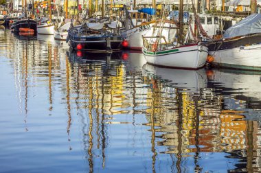 Danimarka 'nın Kopenhag bölgesindeki Nyhavn rıhtımında yelkenli sürüyor. Sudaki yansıma..