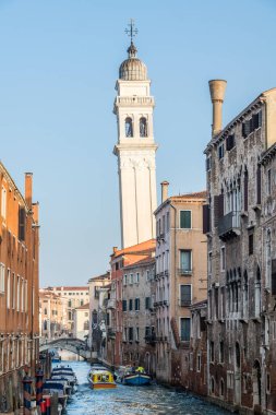 İtalya, Venedik 'te eski binalar ve kilise kulesi olan tipik bir kanal manzarası.