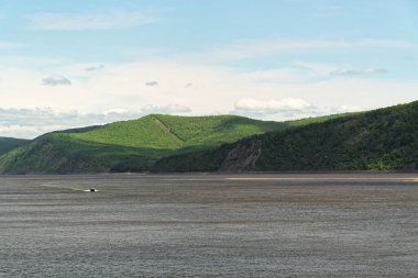 Amur nehri üzerindeki sürat teknesi ormanlık tepelere ve mavi gökyüzüne karşı, Komsomolsk-on-Amur, Rusya