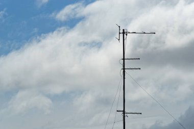 Bulutlu gökyüzüne karşı eski antenler