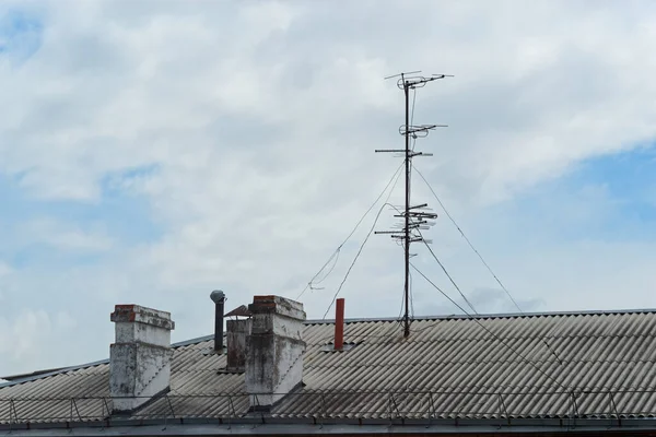 Bulutlu Gökyüzüne Karşı Eski Bir Apartmanın Çatısında Bacalar Antenler — Stok fotoğraf