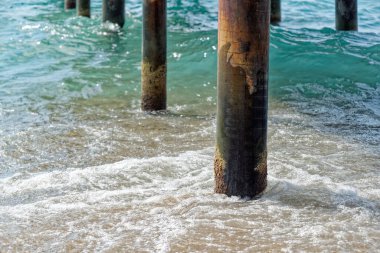 Tahta iskele sütunlarında süzülen deniz suyu manzarası