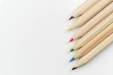 Beyaz arkaplanda bir satırda düzenlenmiş renkli kalemler