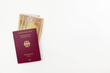 Beyaz arka planda resmi Alman pasaportu ve avro banknotları izole edildi