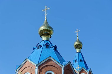 Blue roofs of russian orthodox church against clear blue sky. Cathedral of Our Lady of Kazan in Komsomolsk-on-Amur in Russia clipart