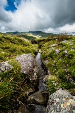 Dağlarda şelalesi olan güzel bir manzara.