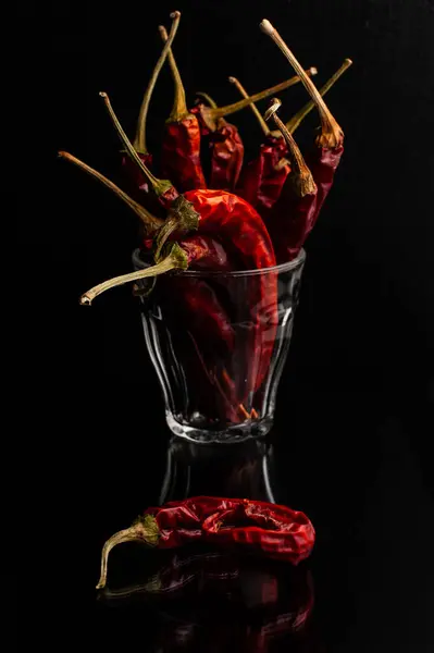 Siyah arkaplanı olan bir bardak kırmızı biber.