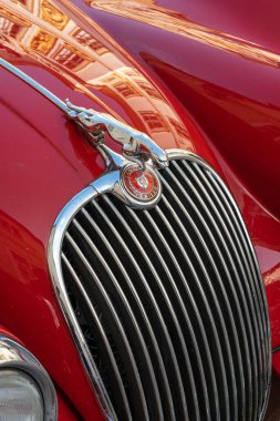 MELK, AUSTRIA - 16 AĞUSTİSTOS 2019: Jaguar Araba Maskotu, klasik klasik bir Jaguar XK 150 'nin önünde krom radyatör ızgarası ve kırmızı logonun ortasında bir Jaguar yüzü var. 