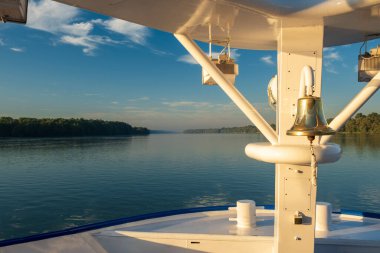 Gündoğumunda yelkenli gemide çan çalıyor.