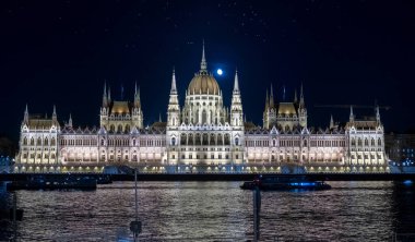 BUDAPEST, HUNGARY - 19 Ağustos 2019: Macaristan Parlamento Binası, aynı zamanda geceleri Budapeşte Parlamentosu olarak da bilinir. Arkasında ay, üstünde martılar