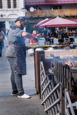 MOSCOW, RUSSIA - 3 AĞUSTOS 2019 İzmailovsky Pazarı. Moskova 'nın varoşlarında bir zanaat pazarı, hediyelik eşyalar ve ikinci el eşyalar. Sakallı bir adam biftek pişirir.