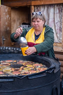 MOSCOW, RUSSIA - 3 AĞUSTOS 2019 İzmailovsky Pazarı. Moskova 'nın varoşlarında bir zanaat pazarı, hediyelik eşyalar ve ikinci el eşyalar. Bir kadın sıcak meyve kokteyli satar.
