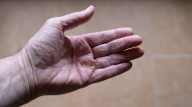 Adam ellerini dezenfektanla temizliyor.