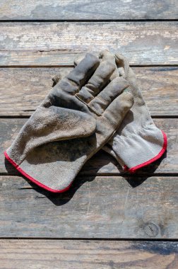 Ahşap bir masada eski çalışma eldivenleri