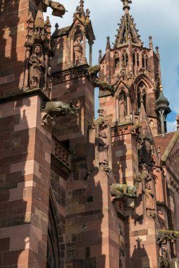 FREIBURG IM BREISGAU, GERMANY - 15 Haziran 2019: Freiburg Minster Freiburg katedrali. Romanca başladı ve Gotik tarzıyla sona erdi. Su hortumları ve diğer heykeller