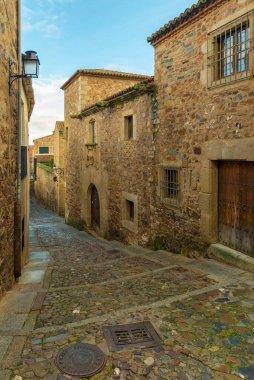 CACERES, İspanya - 25 Kasım 2018: Şehrin tarihi merkezinin tipik ortaçağ dar caddesi