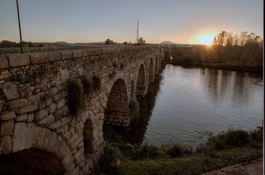 Meridya, BADAJOZ, İSPAN 23 Kasım 2018: Roma köprüsü gün batımında