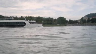DANUBE RIVER, SLOVAKIA - 18 AĞUSTOS 2019: Bir yolcu gemisi gün batımında nehirde yol alır