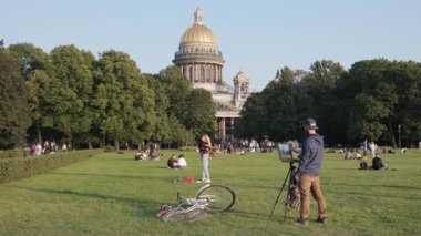 PETERSBURG, RUSSIA - 6 AĞUSTOS 2019: Alexander Garden 'da bir ressam, arka planda St. Isaac Katedrali