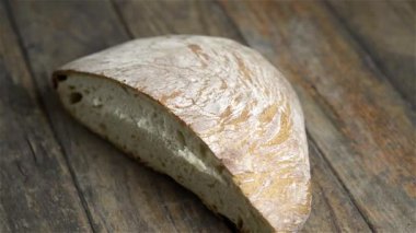 Bir somun ekmek ahşap masada dönüyor.