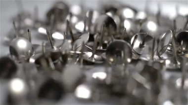 Beyaz arkaplanda dönen parlak metal itme pimi