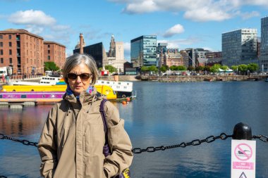 Liverpool, Birleşik Krallık 'taki Albert rıhtımında güneşli bir günde kıdemli kadın turist.