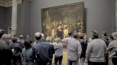 AMSTERDAM, NETHERLANDS - 10 Mayıs 2017: Rijksmuseum 'daki The Night Watch veya The Militia Company of Captain Frans Banning Cocq filmini izleyen insanlar